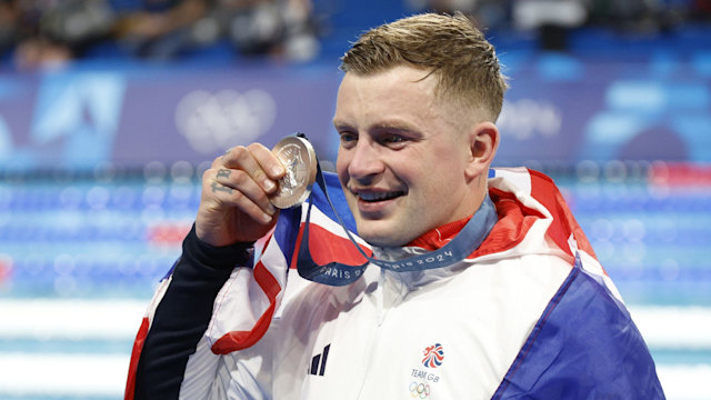 Adam Peaty posing with medal