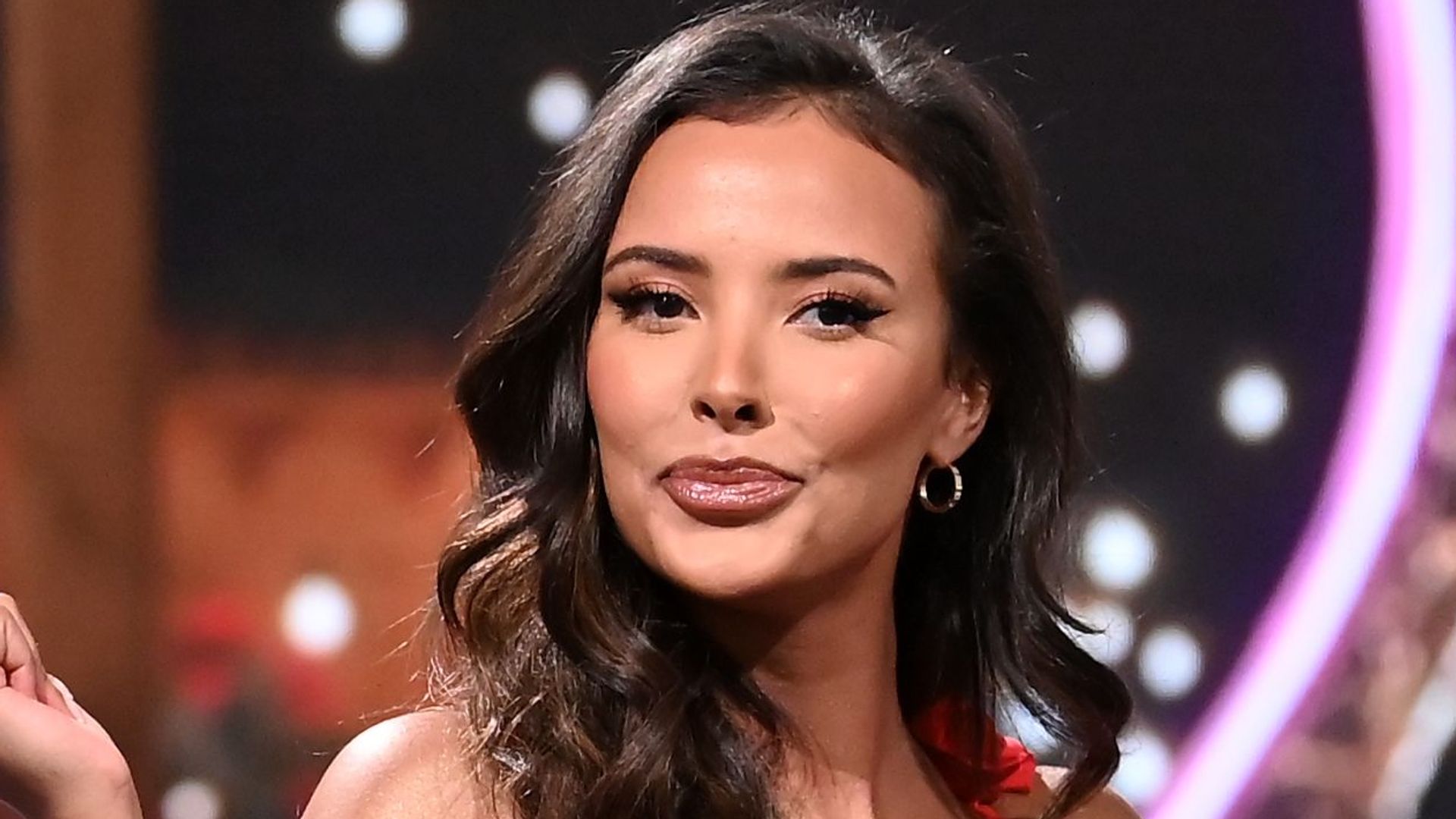 Maya Jama pouting with curly hair while hosting Love Island Aftersun