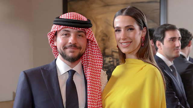 Crown Prince Hussein in a suit and turban and Princess Rajwa in a yellow dress