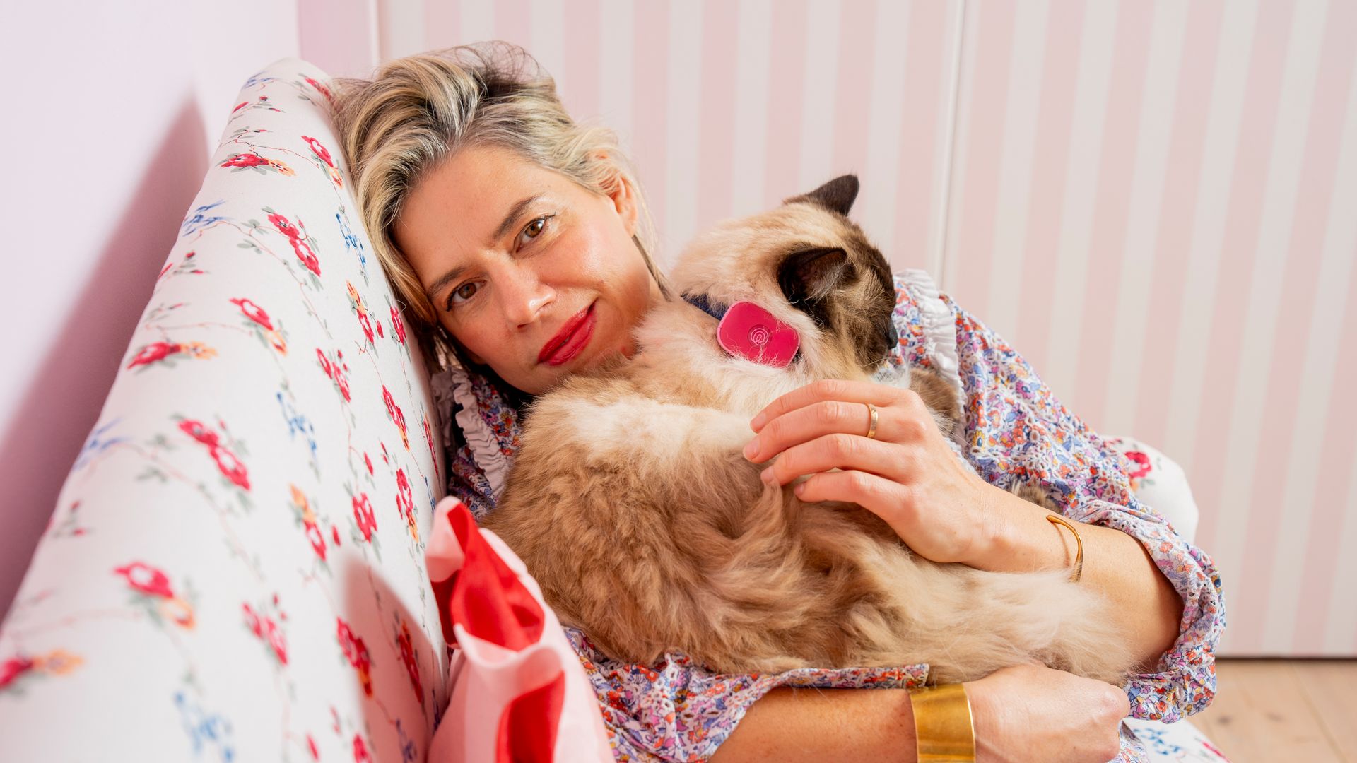 A woman lies on a sofa with a pet cat