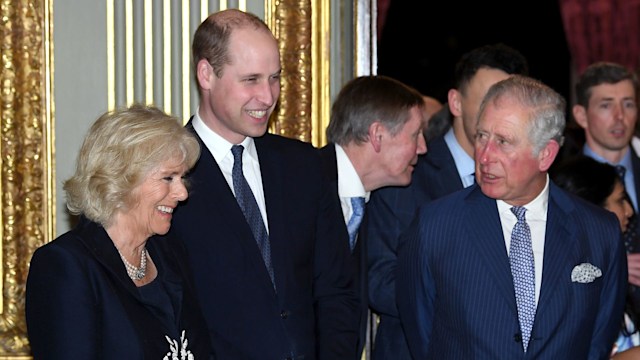 Queen Camilla and Prince William smiling while King Charles looks on