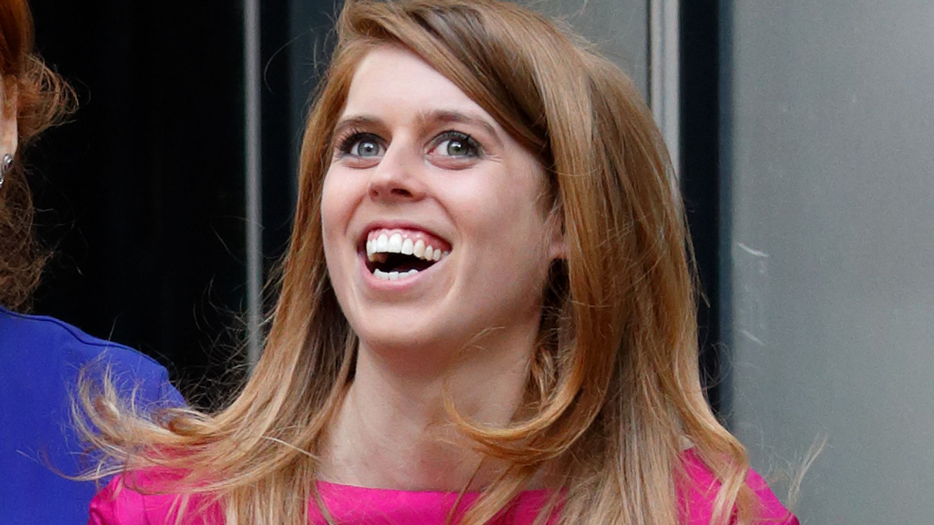 Princess Beatrice laughing in a pink dress