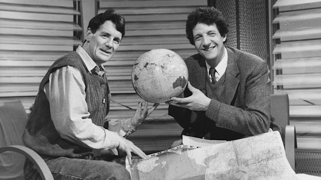 Chris Serle and Michael Palin inspecting a map and globe