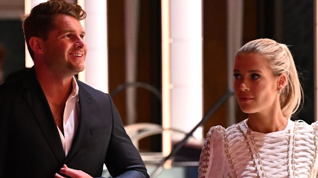 Greg Mallett in a suit walking with wife Lady Amelia Spencer in a white mini dress