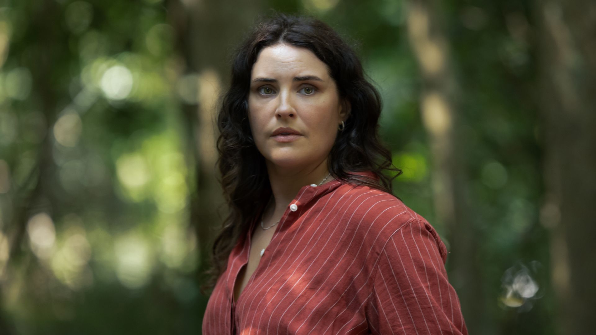 young brunette woman in red shirt in woodland