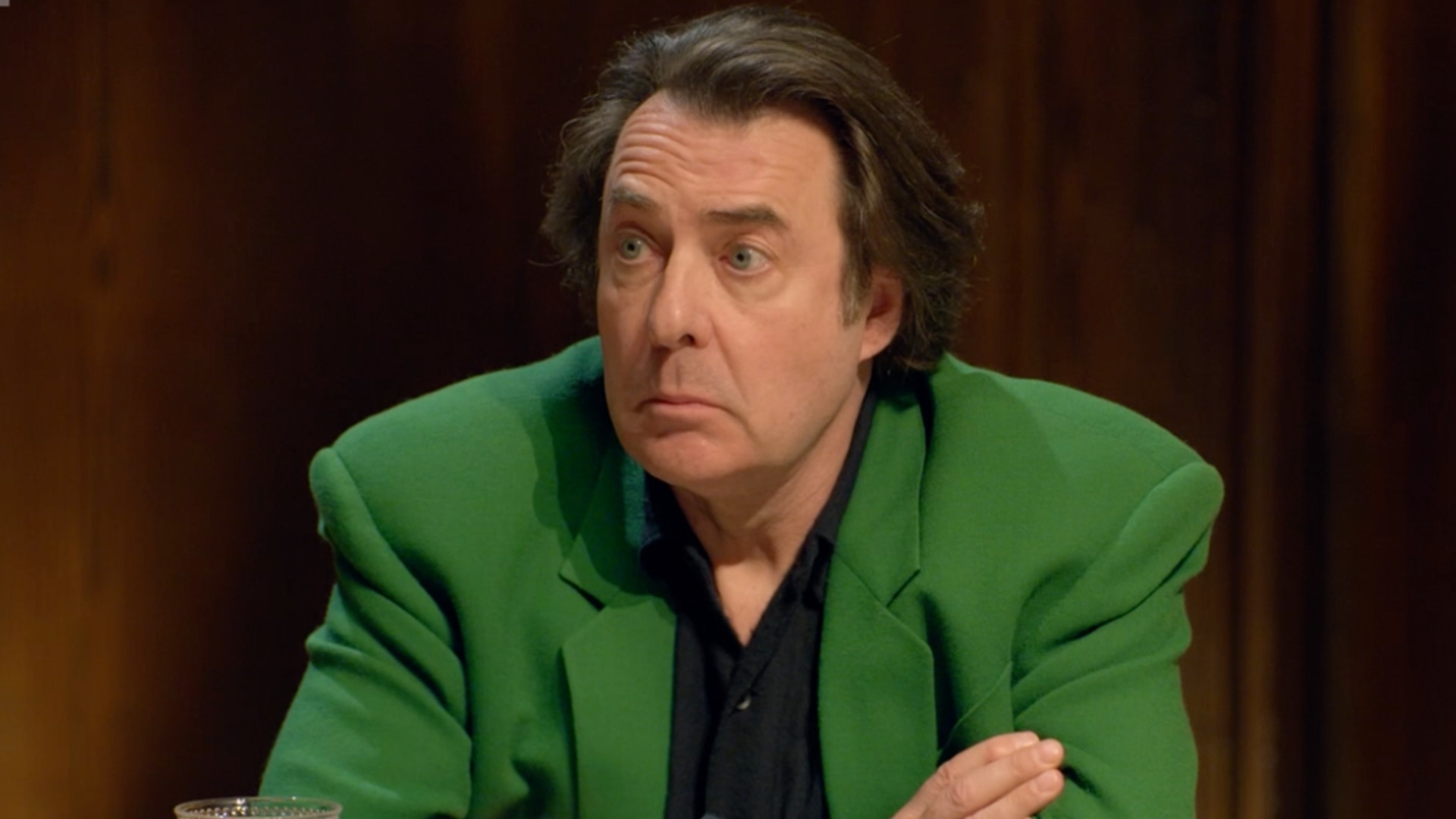 man in green blazer sitting at table 
