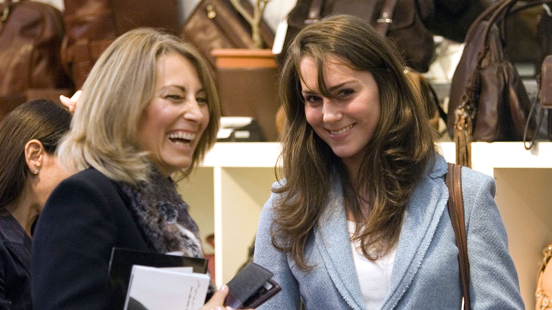Carole Middleton and Kate Middleton laughing in a shop. 
