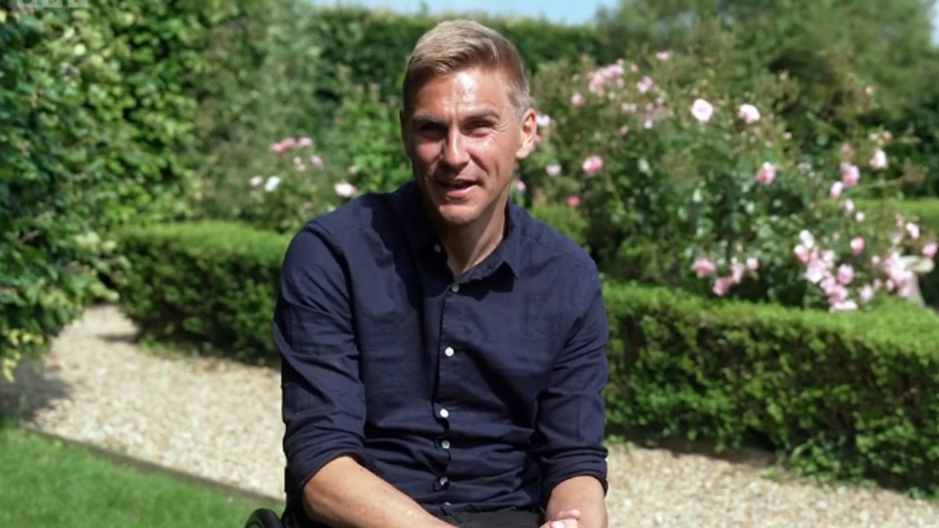 Man sitting in wheelchair in sunny garden