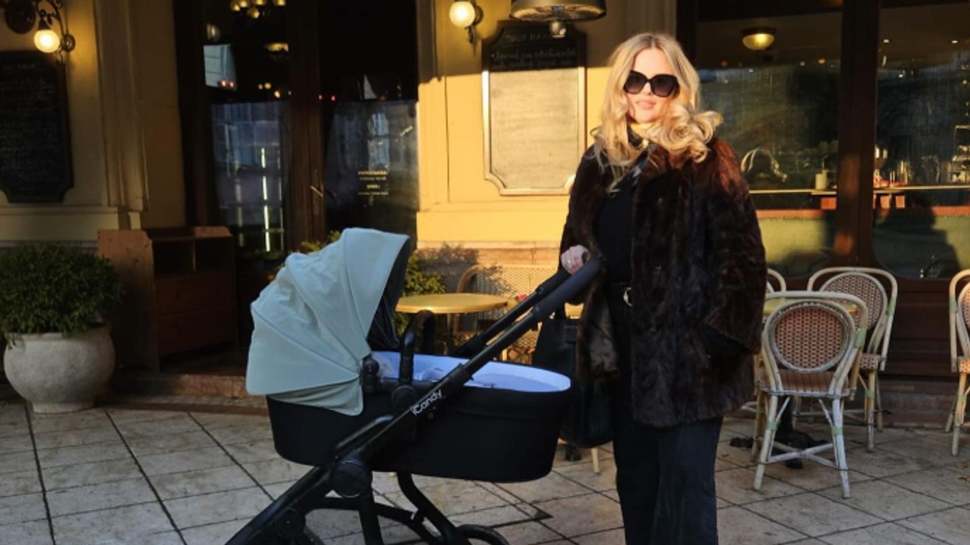 Emily Atack outside a restaurant pushing a buggy