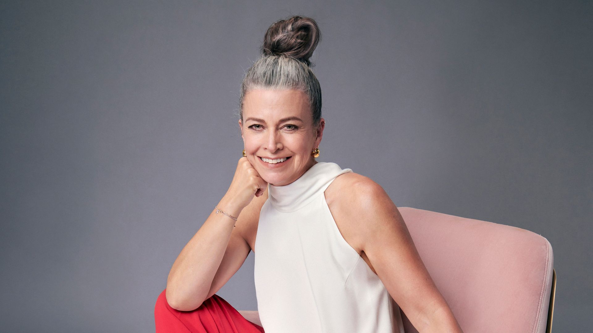 Jane Fallon posing on a pink velvet chair 