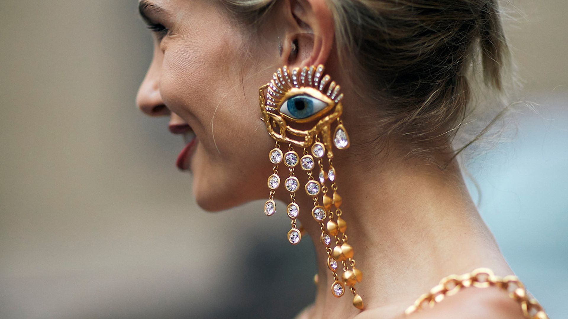 woman with eyeball earrings by schiaparelli with blonde hair in a bun