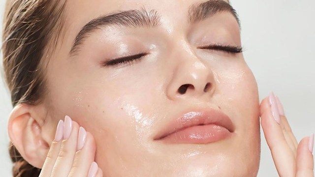 woman rubbing her face after a facial 