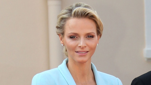 Princess Charlene in blue blazer and skirt and Prince Albert in suit