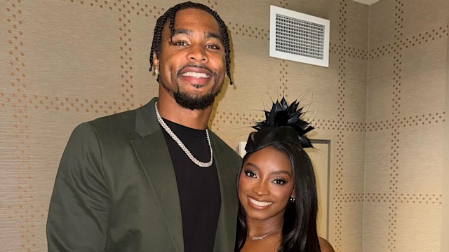simone biles and jonathan owens posing in hotel