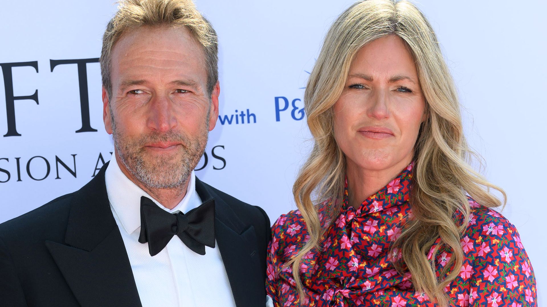 Ben Fogle in a tuxedo and bow tie with wife Marina in a pink dress