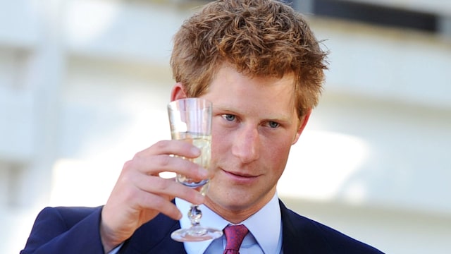 Prince Harry raising a glass in a suit