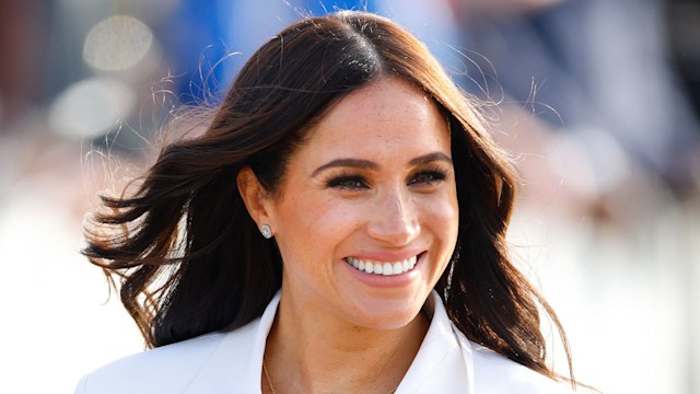 Meghan, Duchess of Sussex smiling in white blazer 