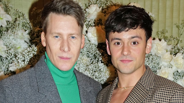 Dustin Lance Black in a green jumper and grey jacket and Tom Daley in a checked suit