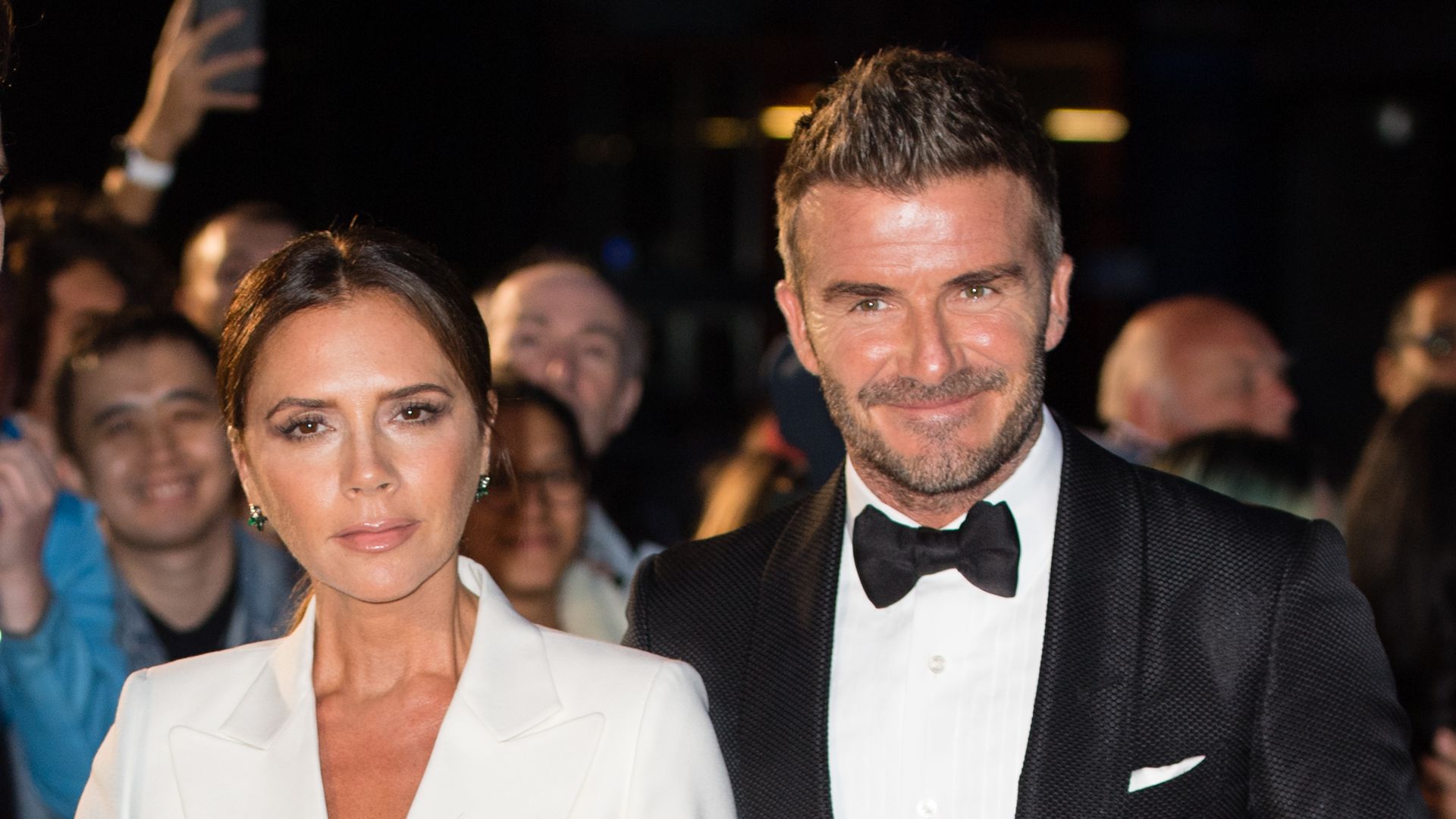Victoria and David Beckham in a white suit and tuxedo