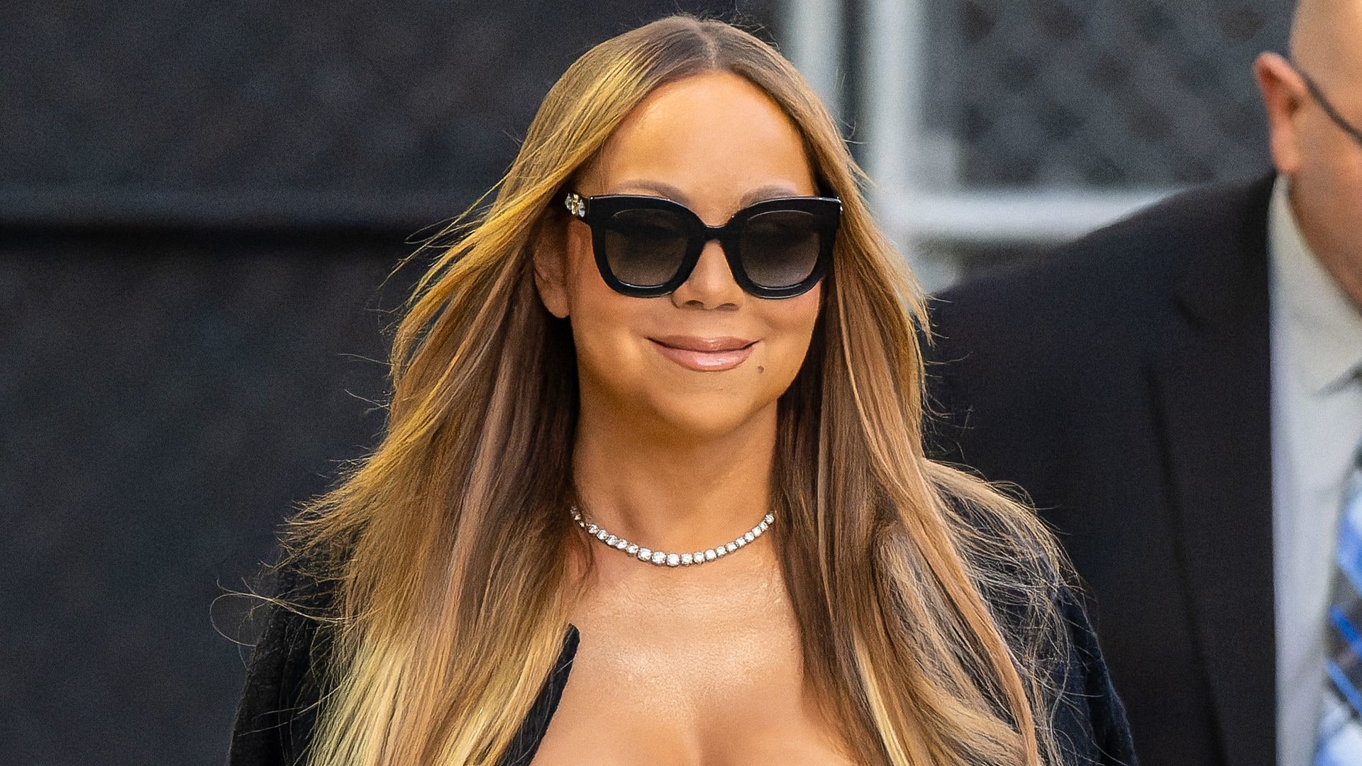 Mariah Carey smiling and wearing sunglasses with hair down loose leaving Jimmy Kimmel