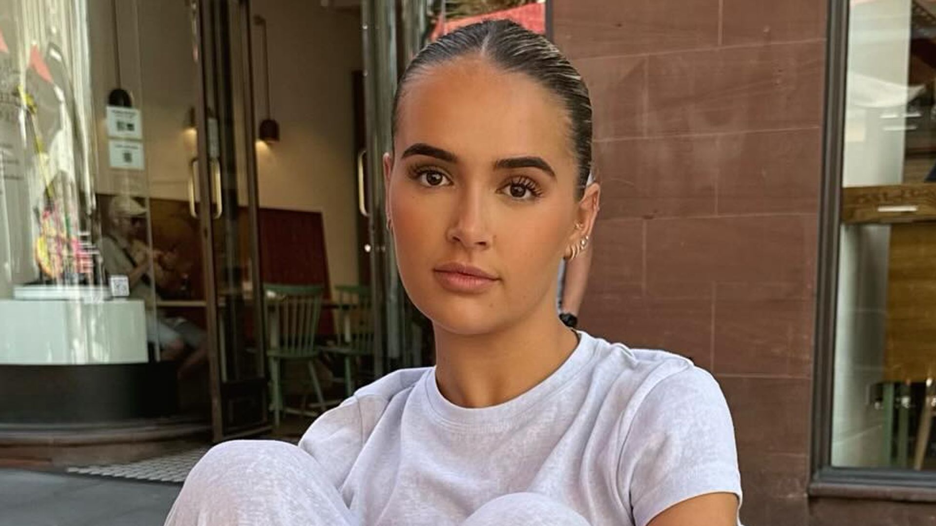 Molly-Mae Hague poses in a grey t-shirt and grey pants