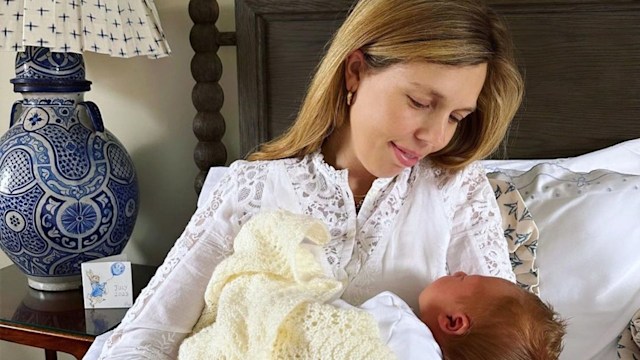 Carrie Johnson in bed cradling a baby