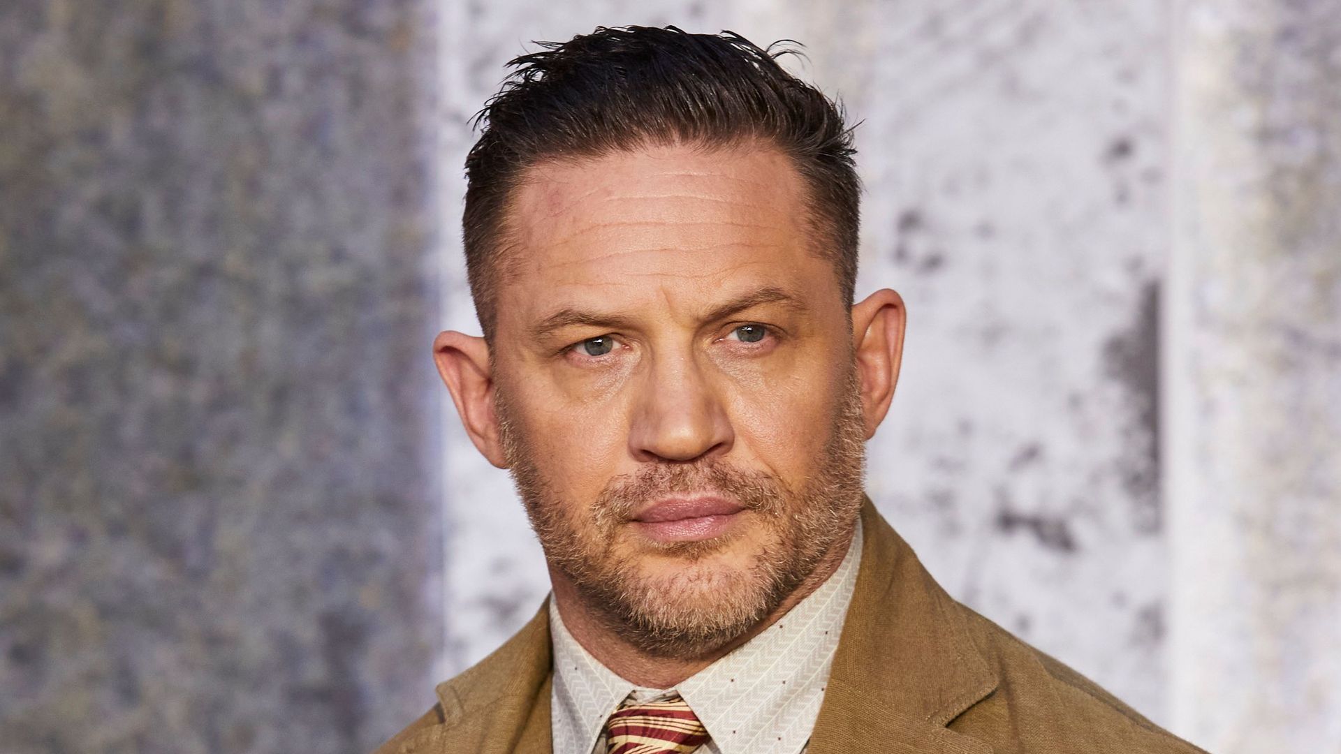 man in suit with hands in pockets 