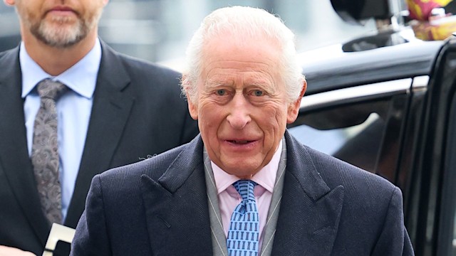 King Charles leaving a car in a black suit