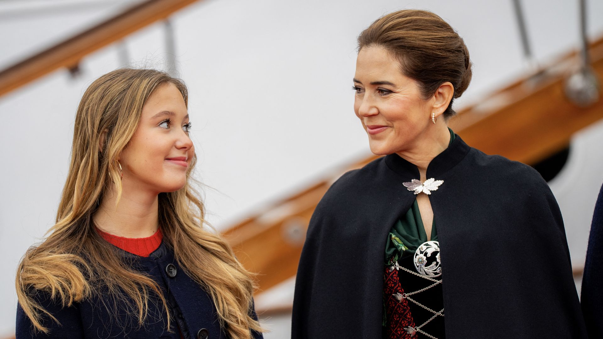 Denmark's Queen Mary and her daughter Princess Josephine (L) smile at each other upon their arrival with the Royal Yacht  in Torshavn