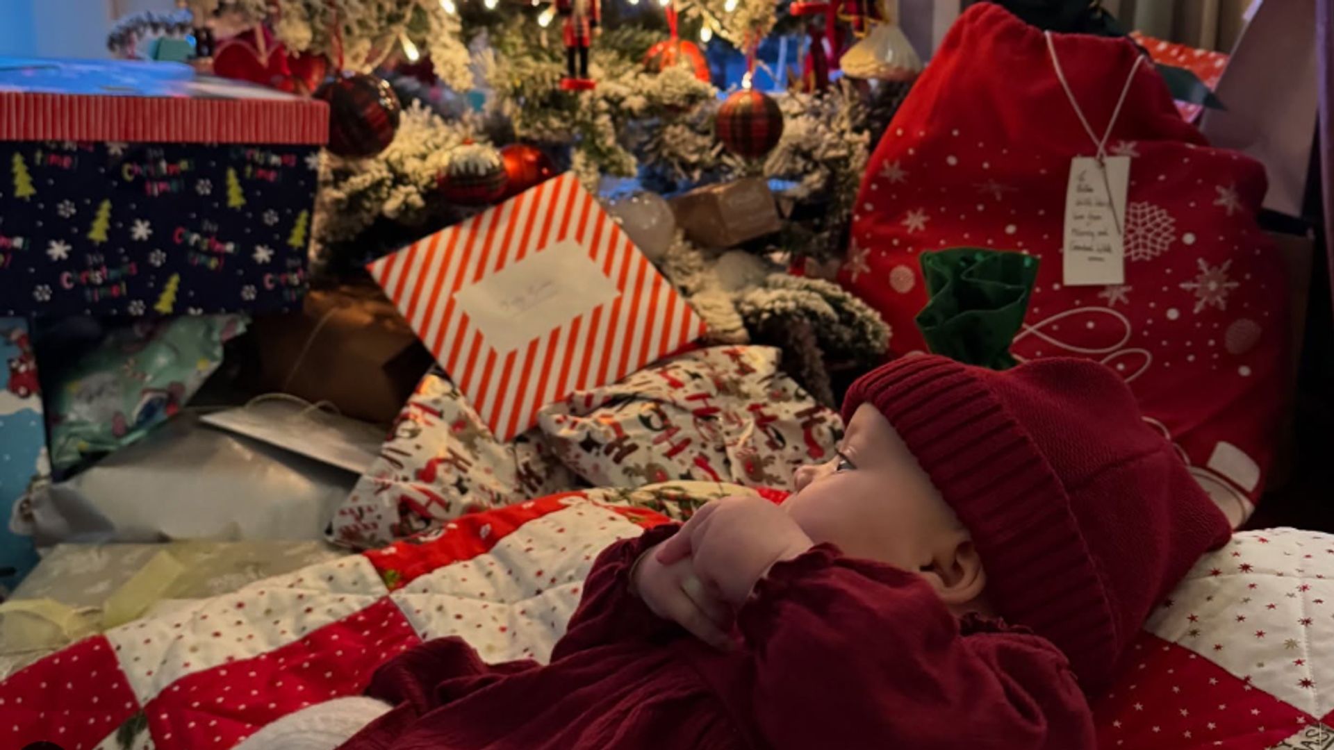 A baby in front of a Christmas tree