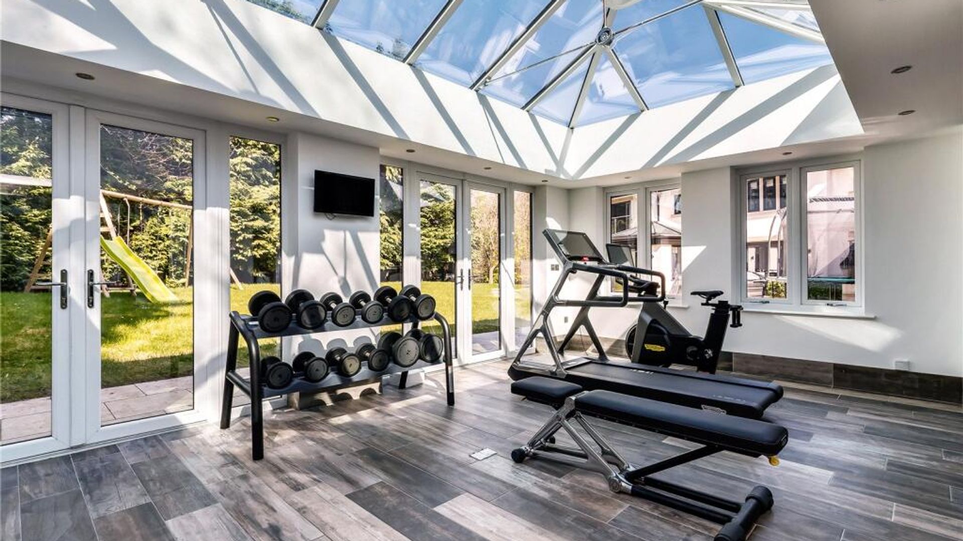 An indoor gym with cycle machines and weight sets