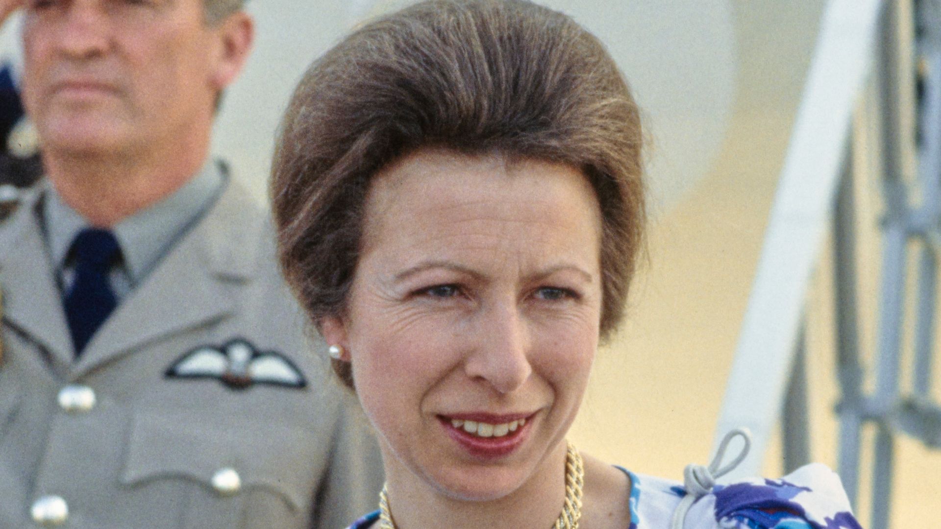 Princess Anne coming off plane in 1980s in blue floral dress