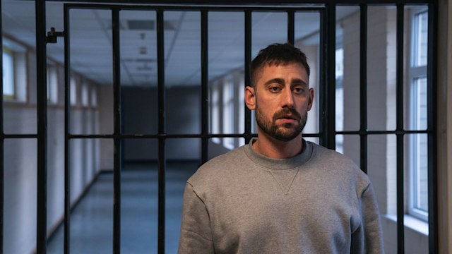 Michael Socha in character in a jail cell