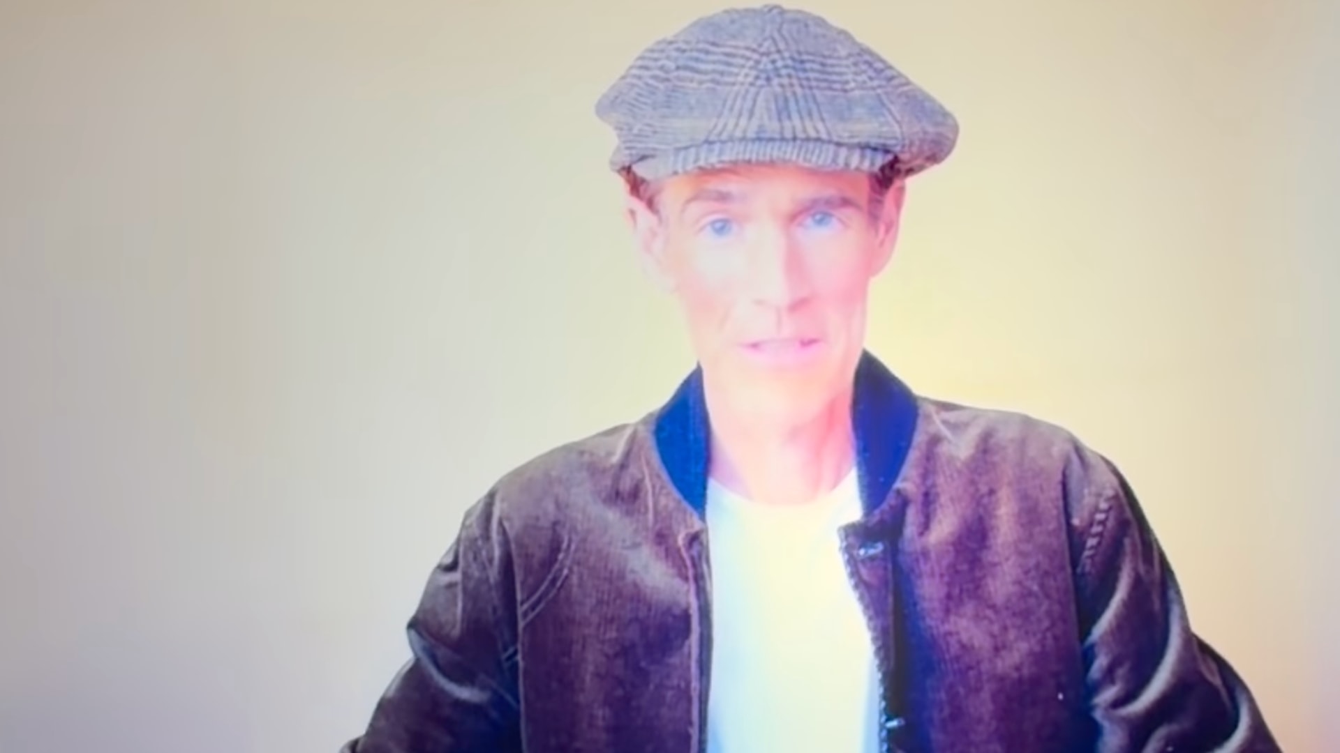 James looking slim, wearing a hat and jacket on virtual screen