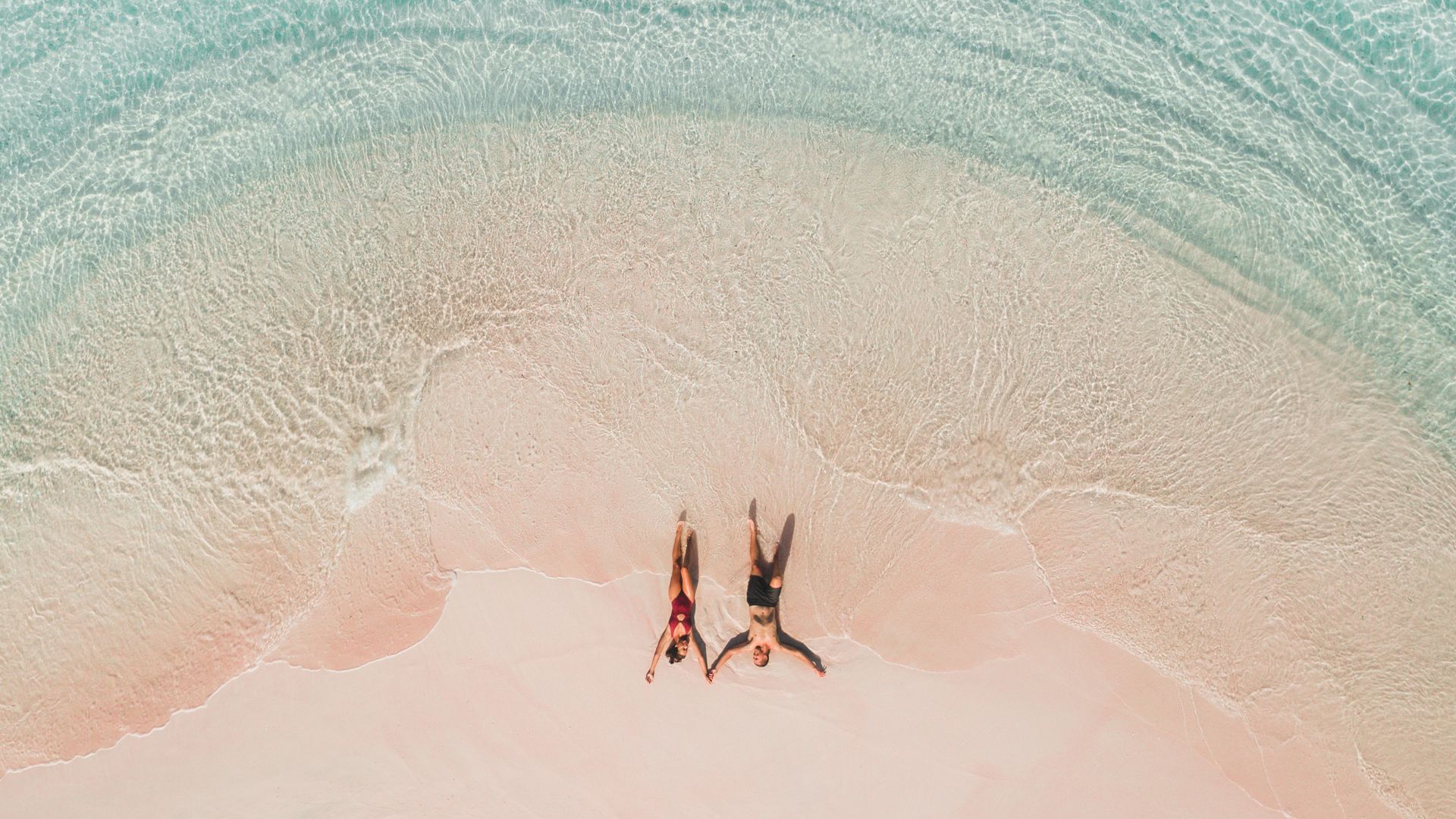 Couple lying on famous pink beach in Komodo national park