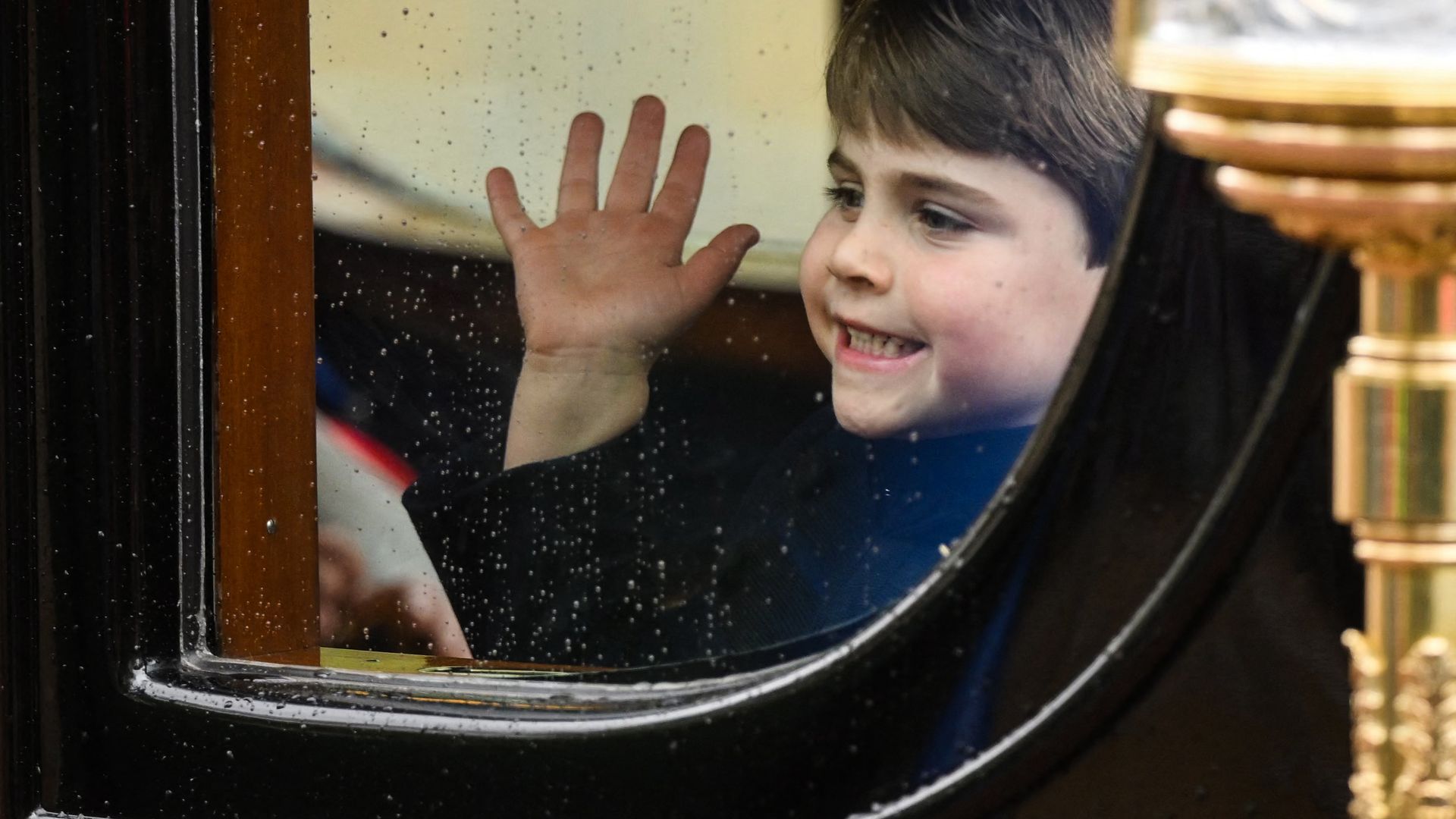 boy waving from inside carriage