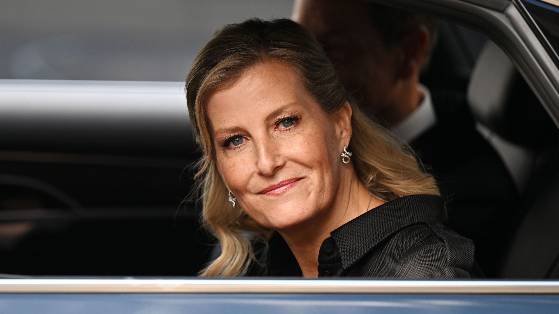 Duchess Sophie smiling in black looking out of a car window