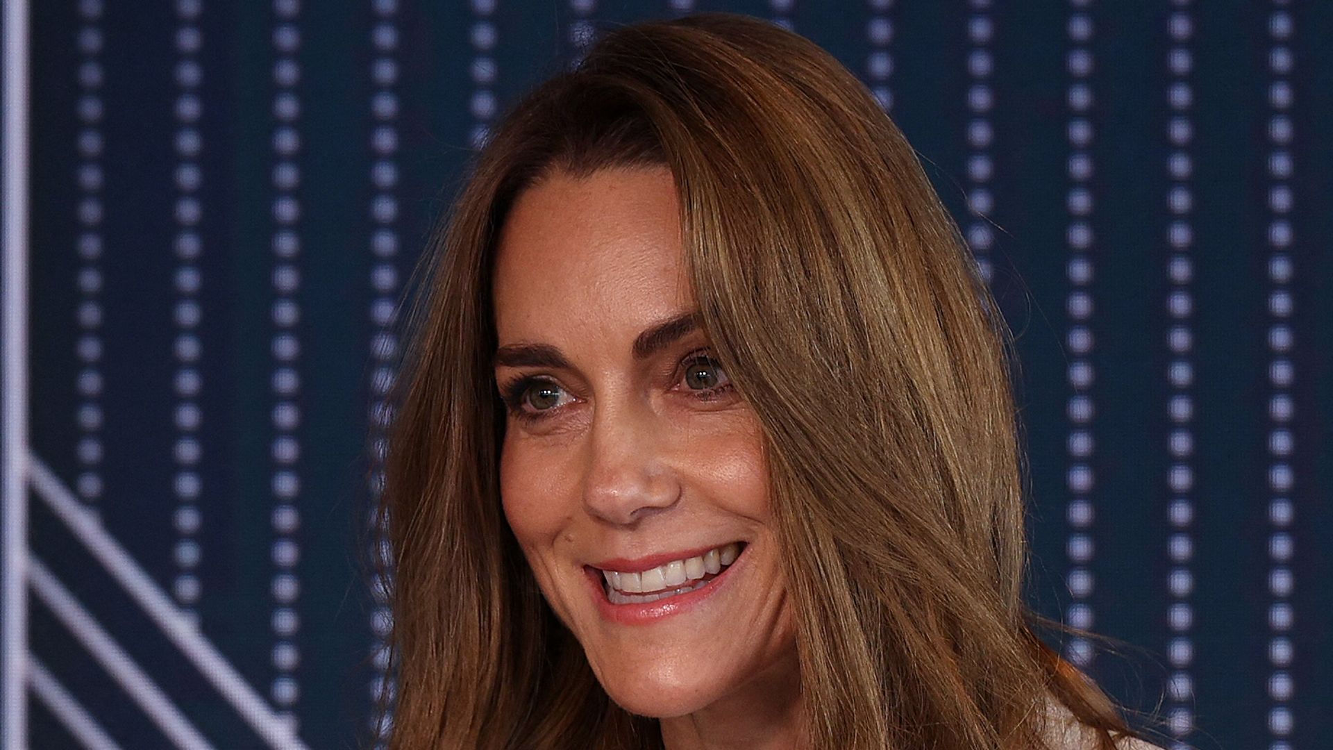 Princess of Wales speaks at podium in grey suit