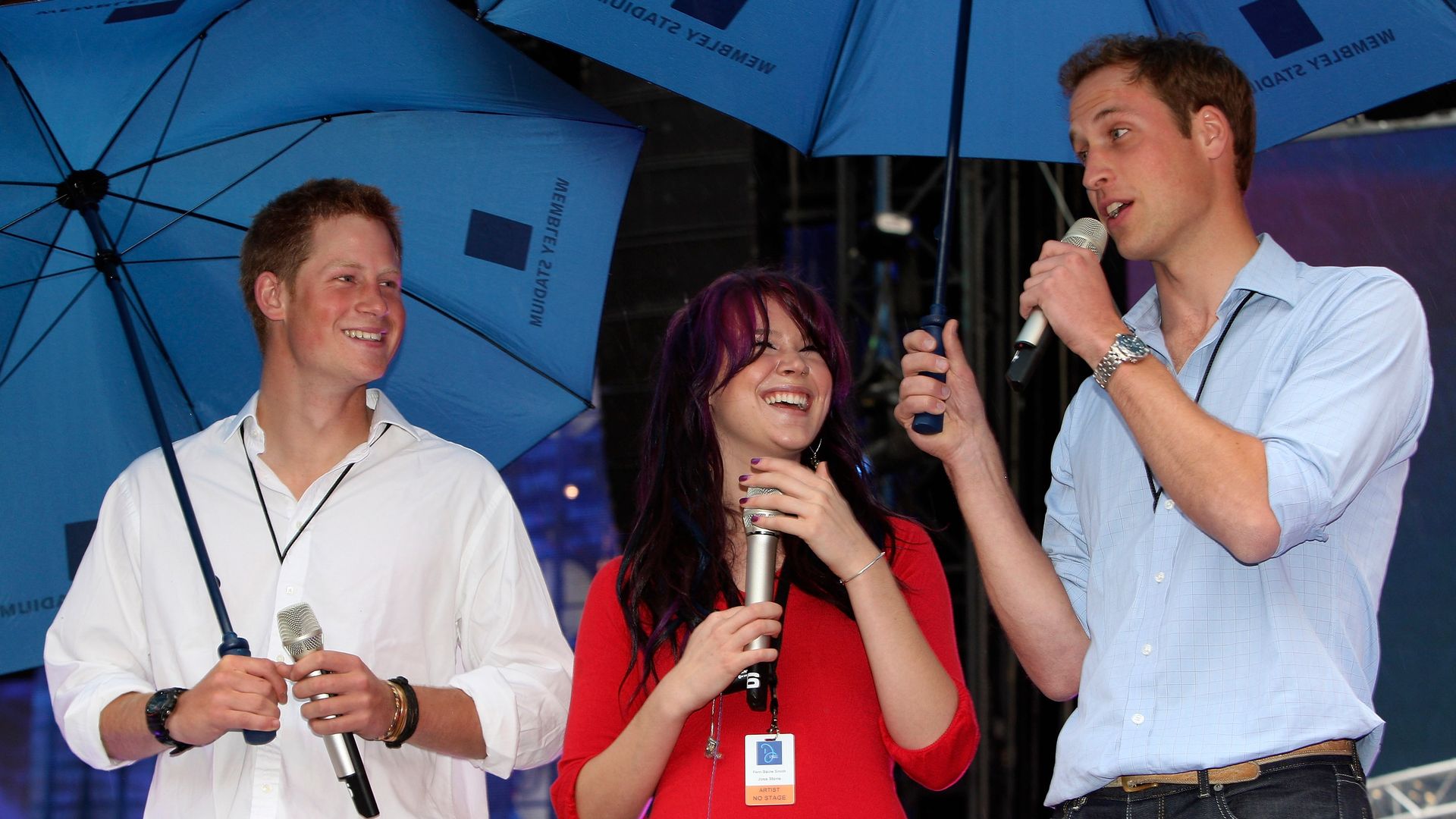 Prince Harry, Joss Stone and Prince William underneath umbrellas