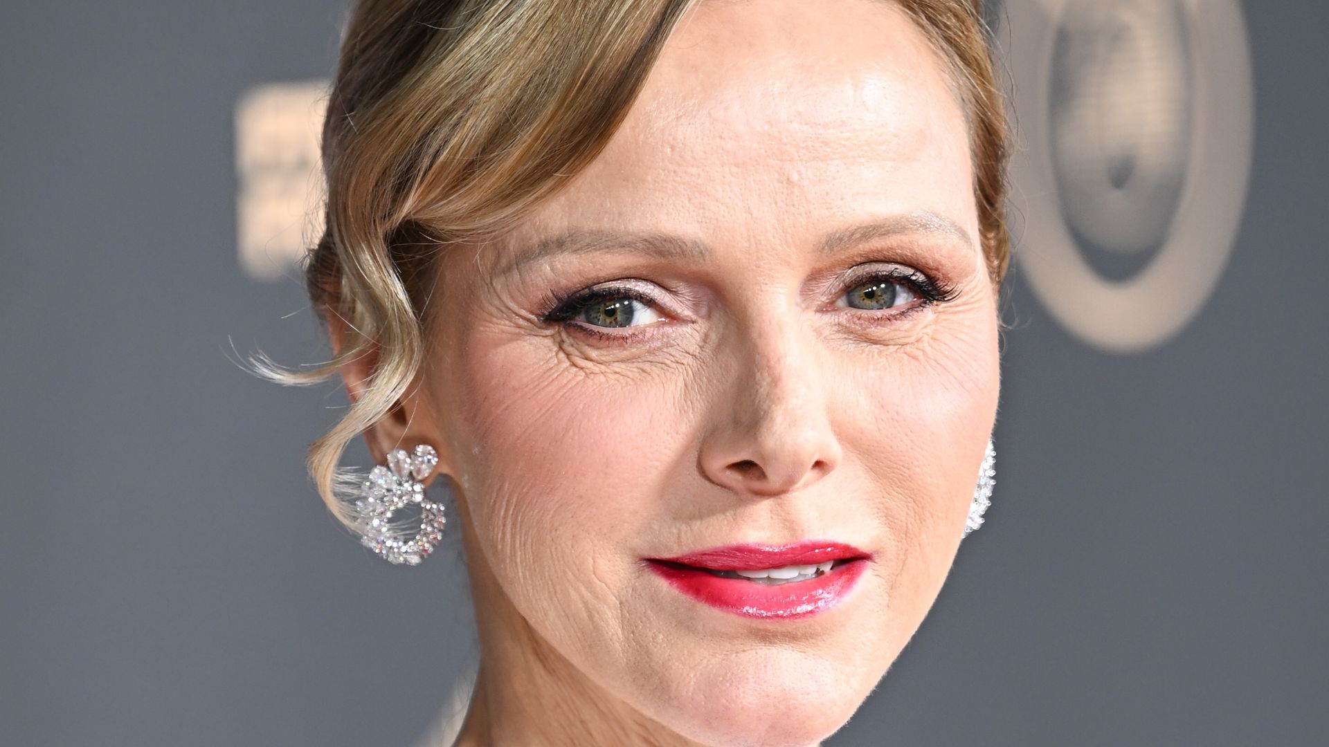 Princess Charlene close up in white gown with hot pink glossy lipstick