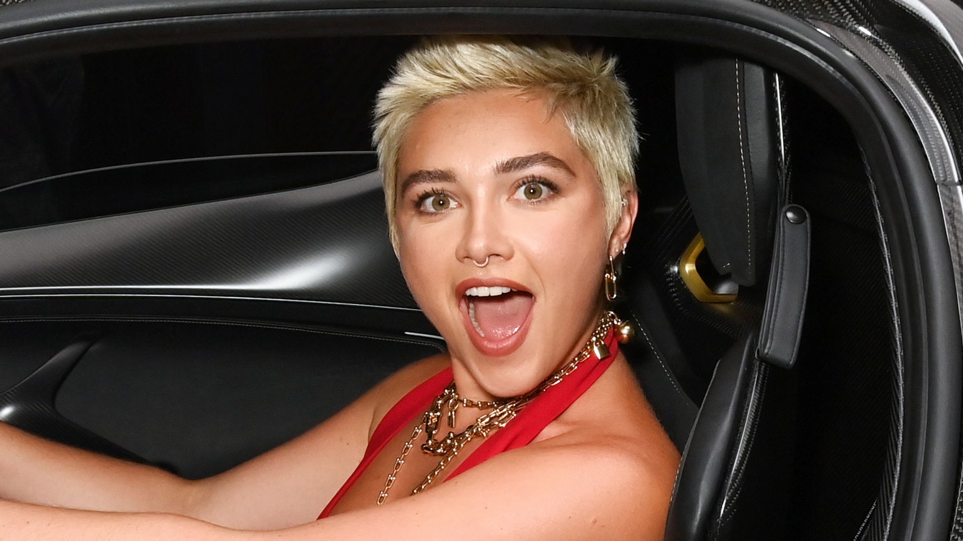 Florence Pugh smiling widely in a car