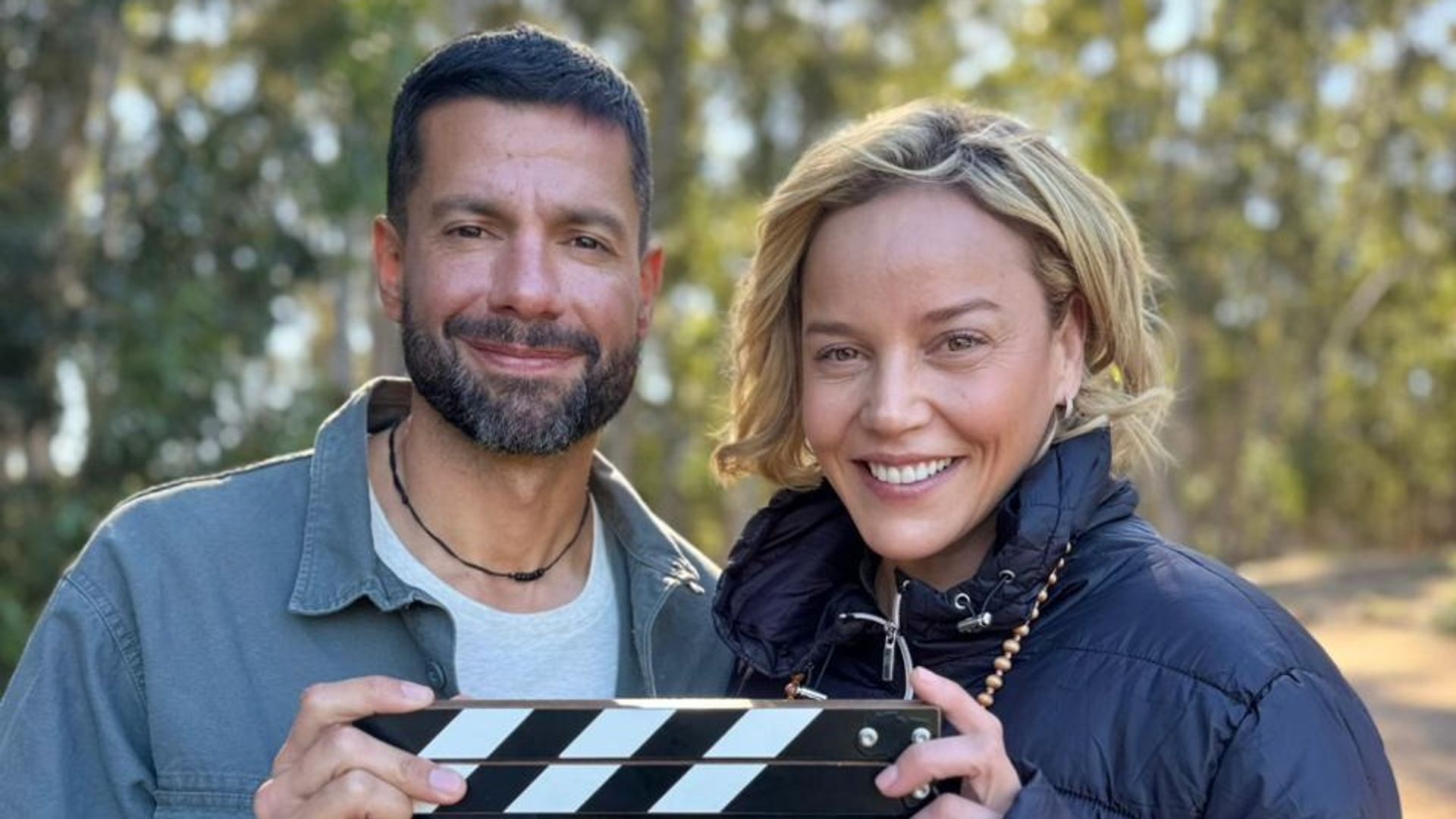 Two people hold a clapperboard