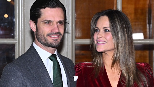 Prince Carl Philip in a grey suit and green tie with Princess Sofia in a red velvet dress