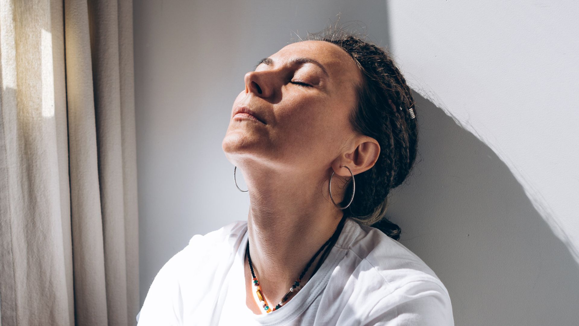 bohemian woman sitting next to window