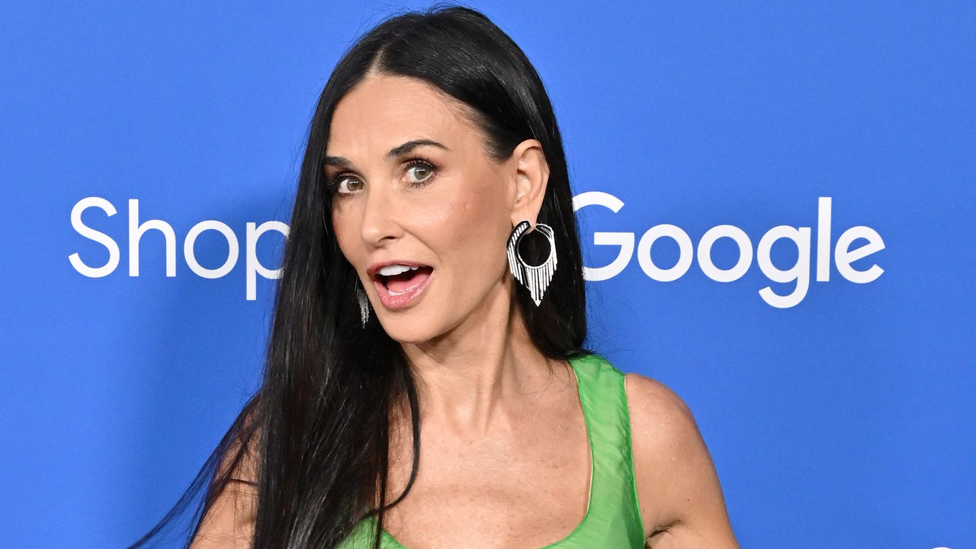 Demi Moore looking surprised in a green dress
