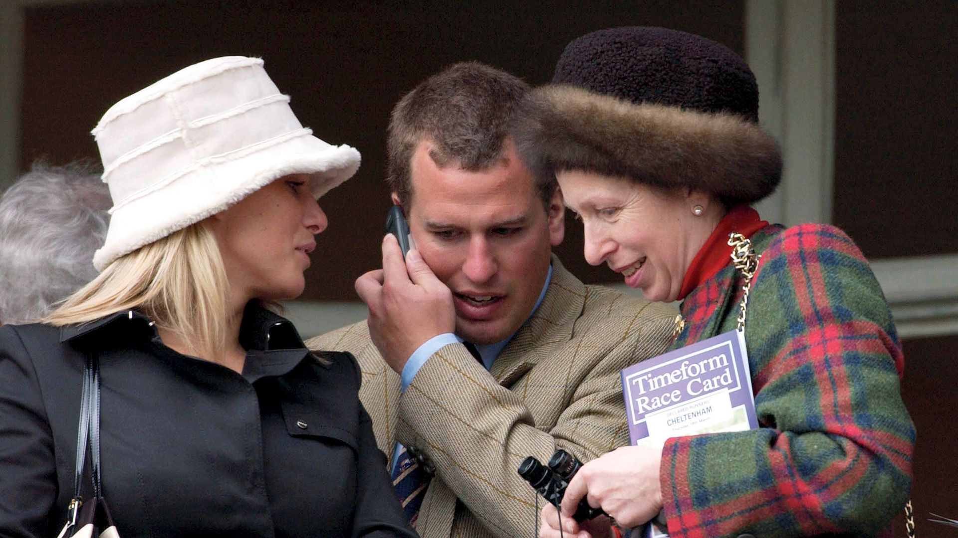 CHELTENHAM, UNITED KINGDOM - MARCH 18:  As Peter Phillips Chats On His Mobile Phone Princess Anne And Zara Phillips Move In Close To Listen At The National Hunt Festival At Cheltenham Races  (Photo by Tim Graham Photo Library via Getty Images)