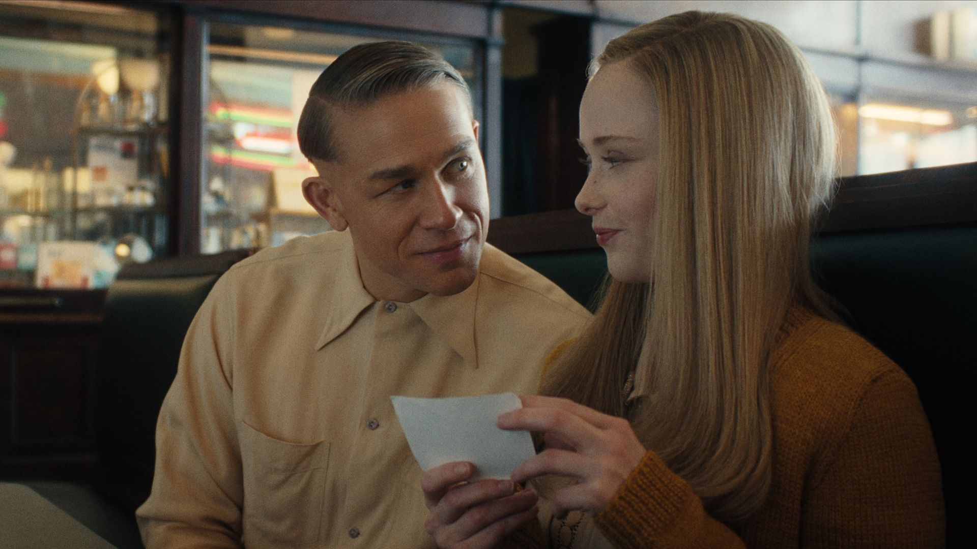 man and woman sitting in booth in diner