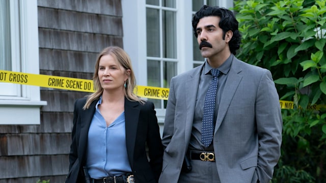 female and male police officer standing in front of house