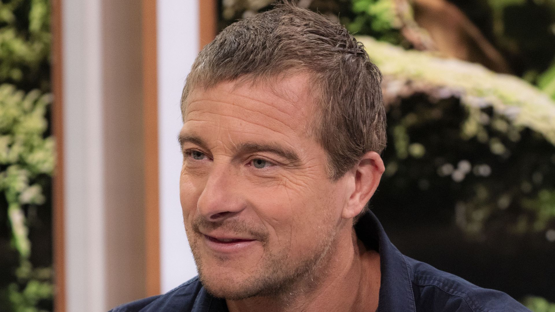 bear grylls on sofa in blue shirt 