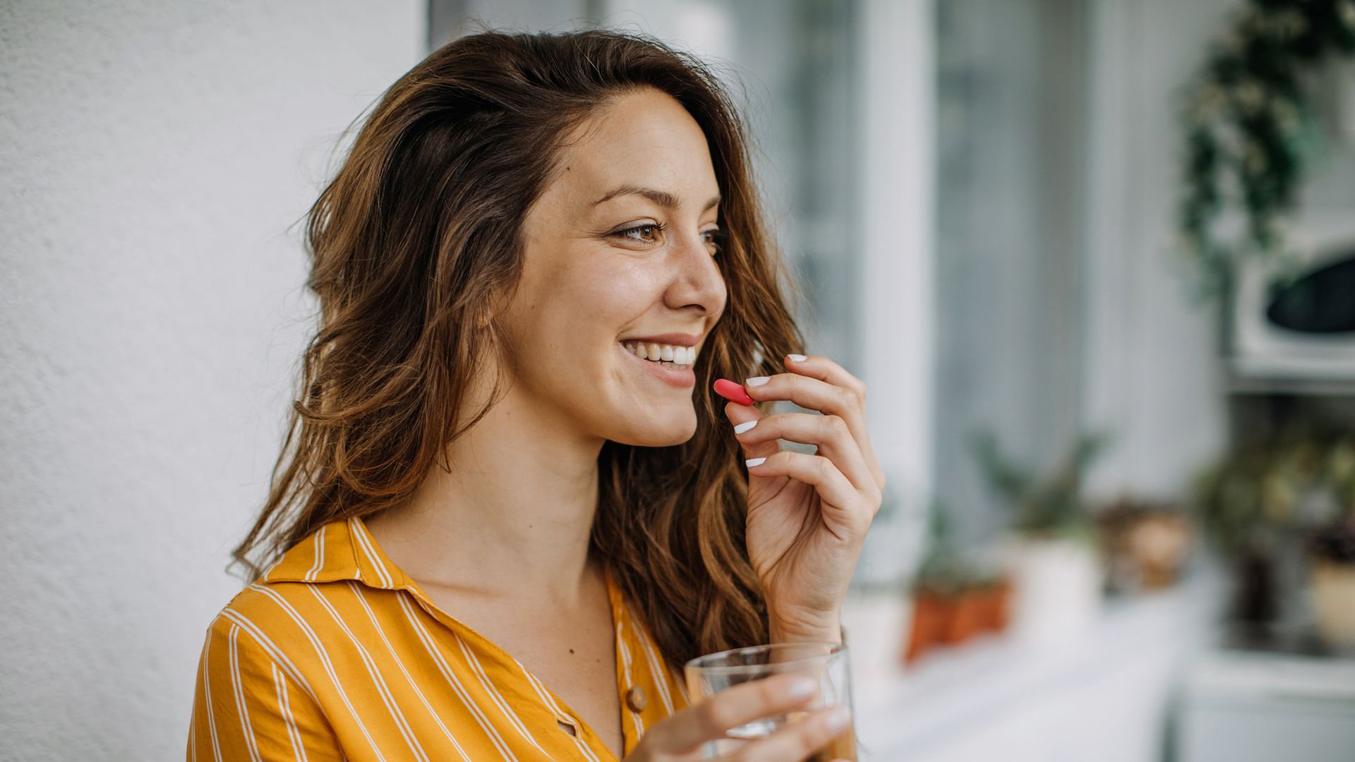 Midlife woman takes supplements at home
